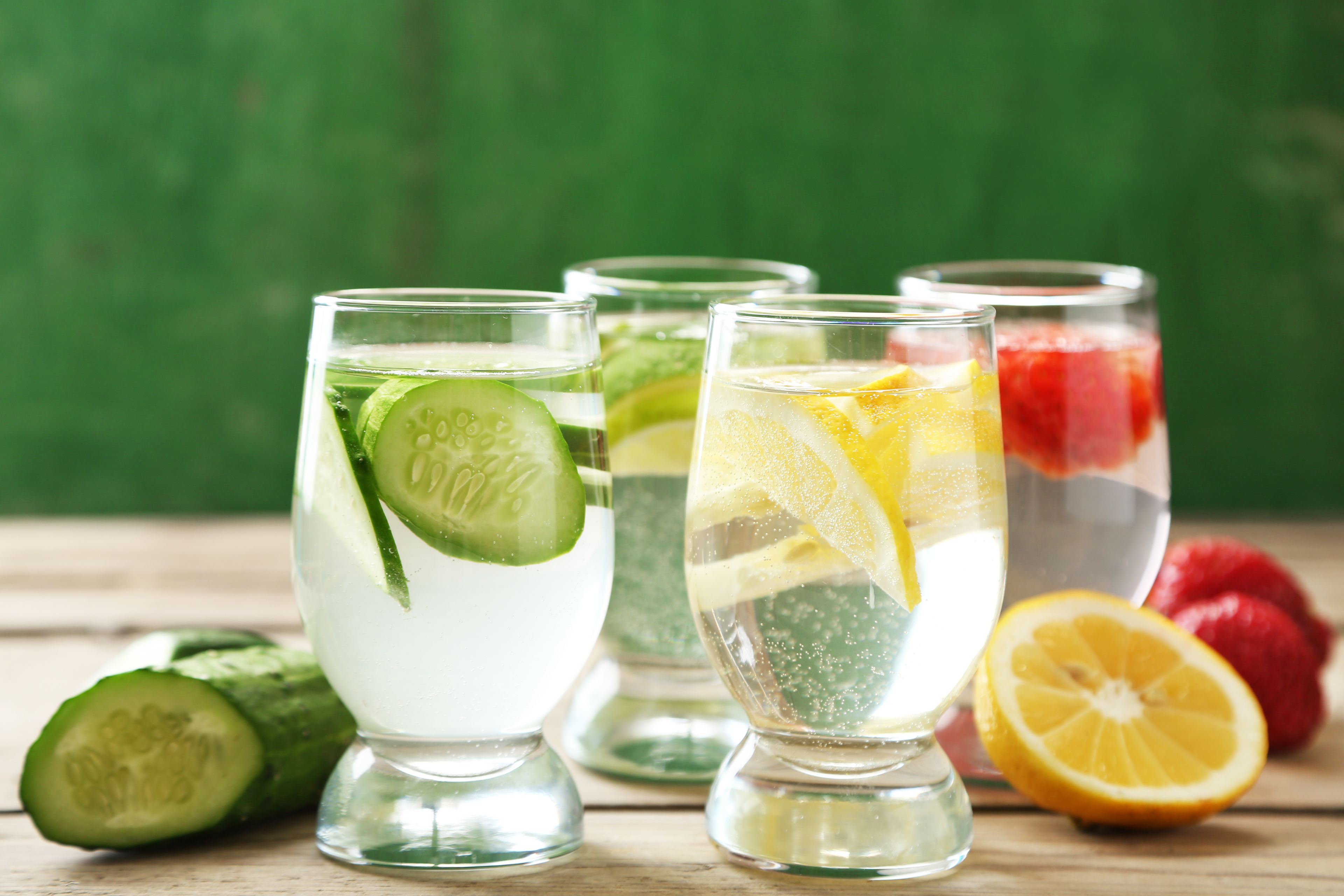 4 glasses of THC drinks with various THC beverage flavors: cucumber, lemon, lime, and raspberry