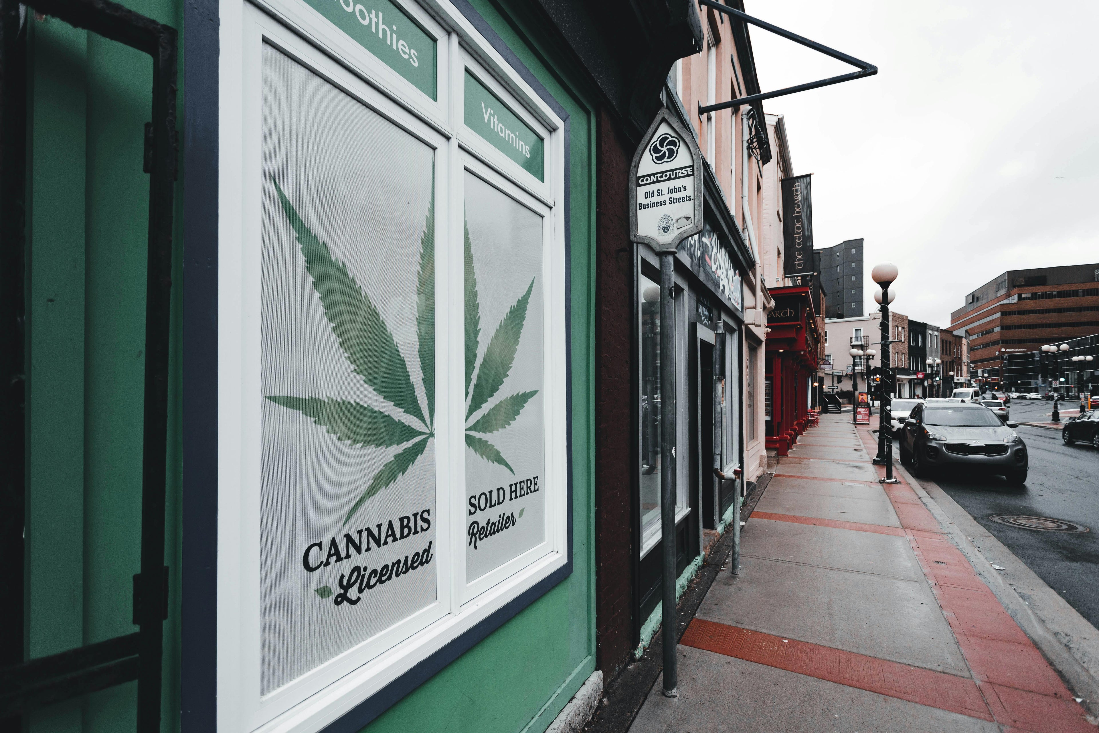 storefront of a cannabis retail location with a glass window on a commercial street