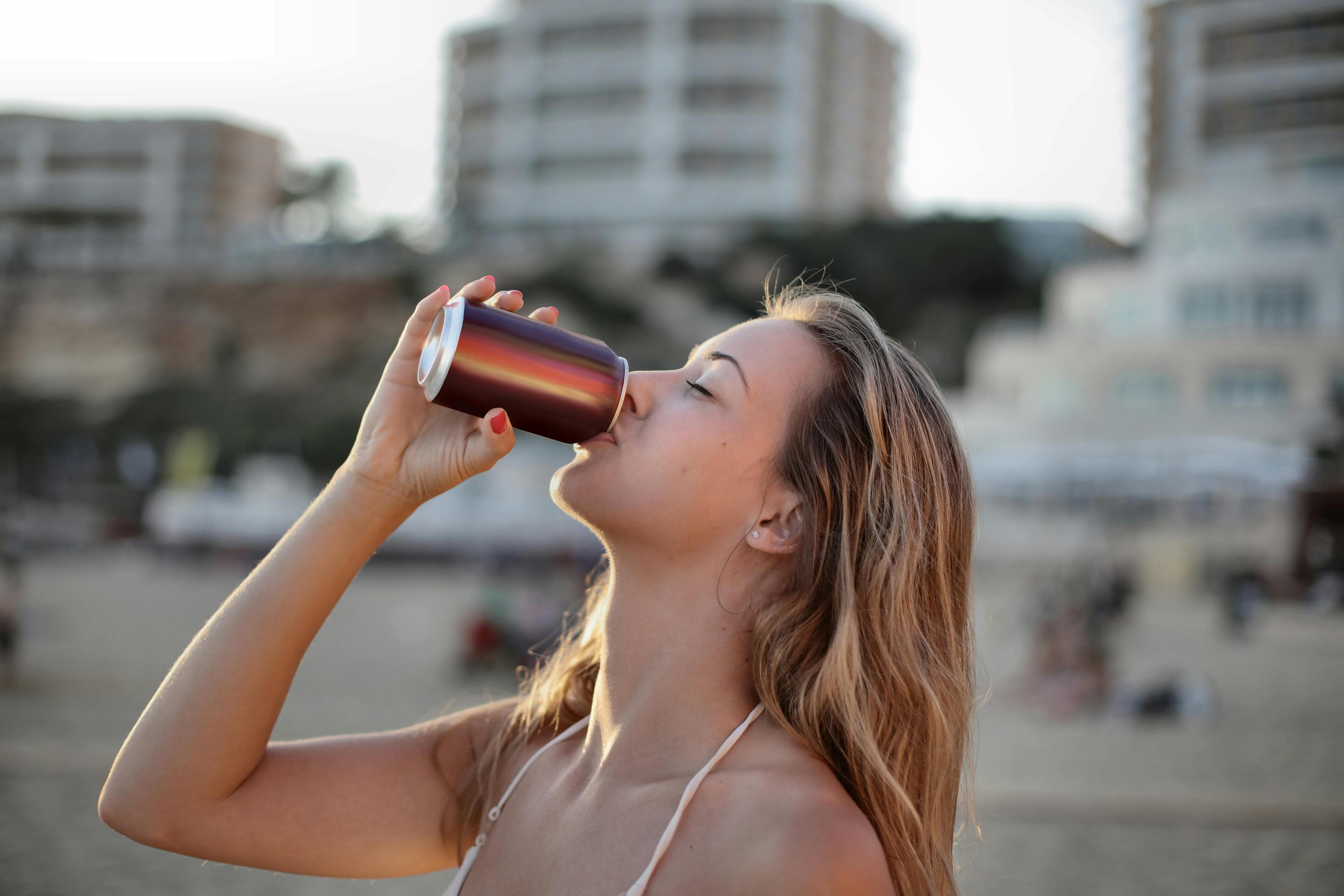 woman practicing functional drinking by sipping on a can of functional beverage